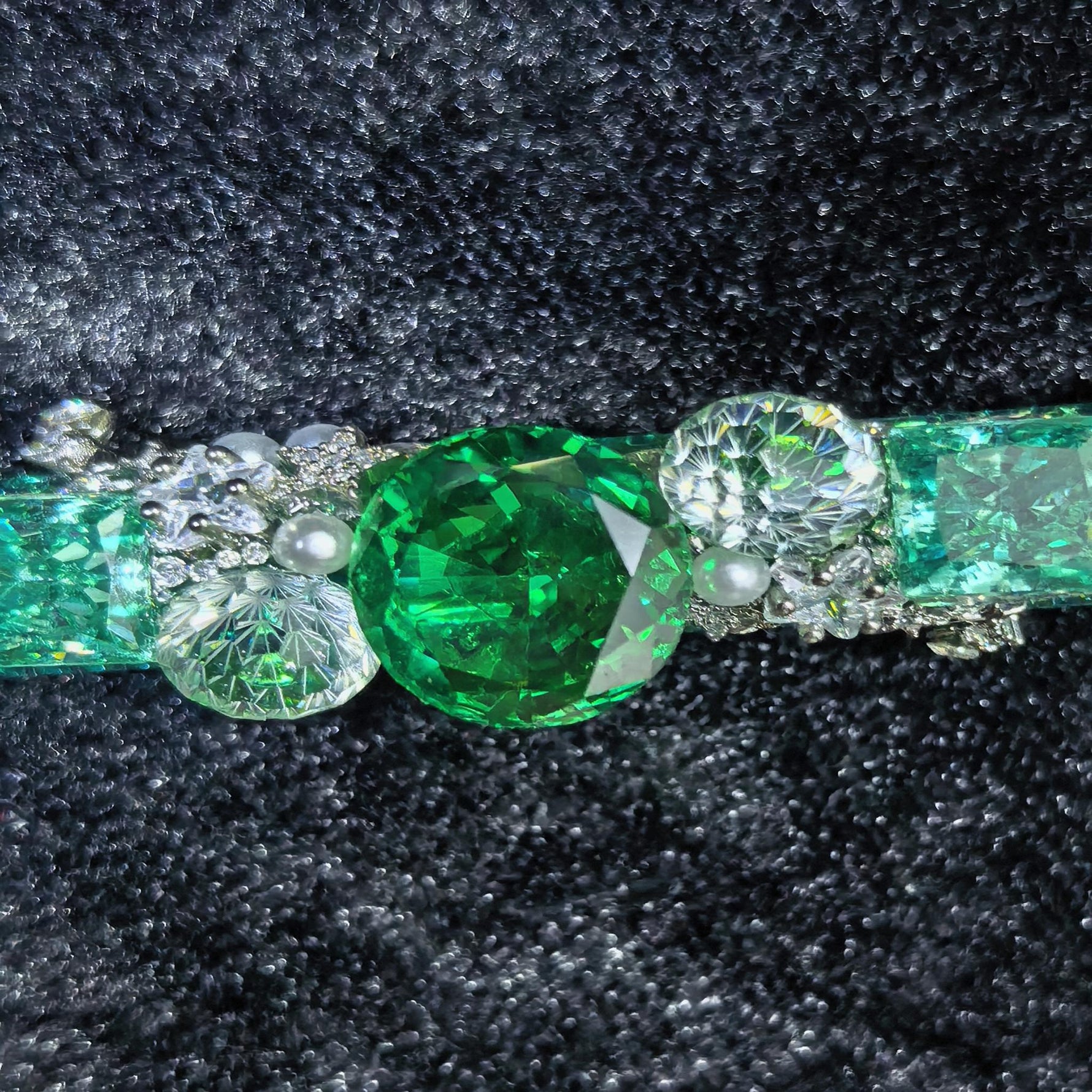 close‑up view of faceted emerald and paraiba cubic zirconia one‑of‑a‑kind handmade hair clip